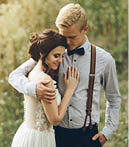 groom gently embracing his bride in the forest