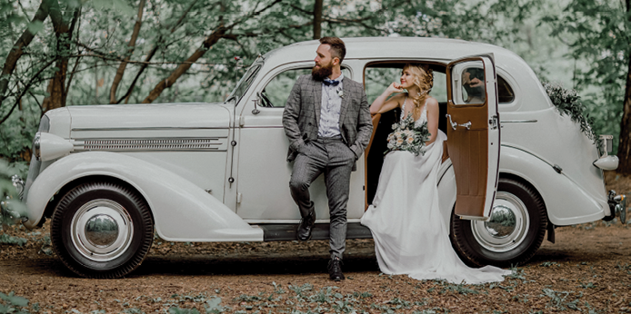 The bearded groom and beautiful bride. Retro car.