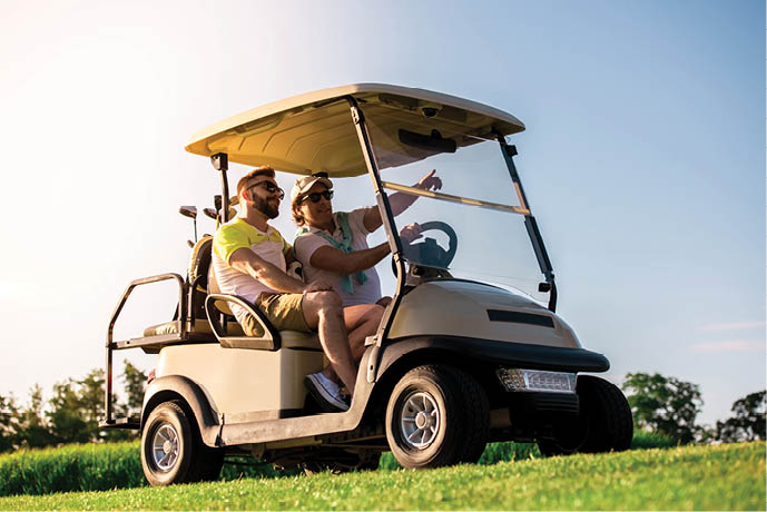 Handsome men are talking and smiling while driving a golf cart and searching for a golf hole