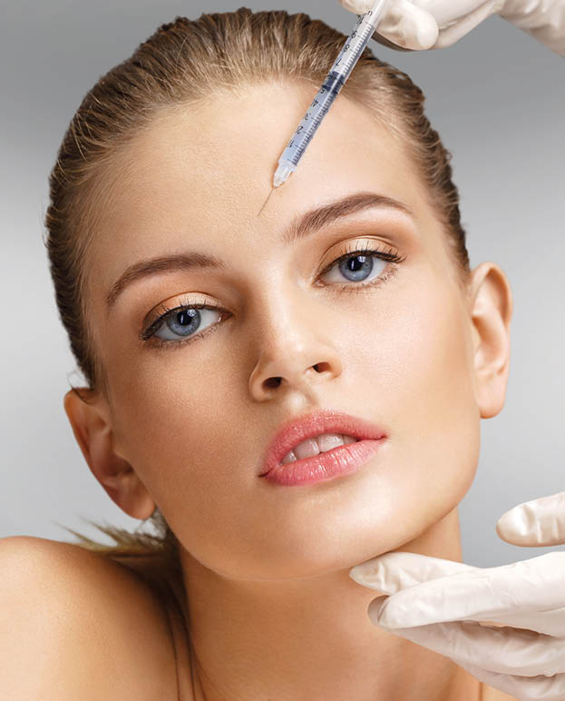 Beautiful woman face and beautician hands with syringe makes cosmetic injection in forehead. Clean Beauty concept