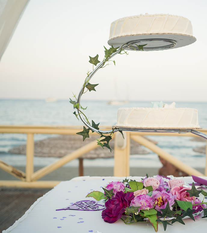 two tiers of cakes at a wedding reception by the beach