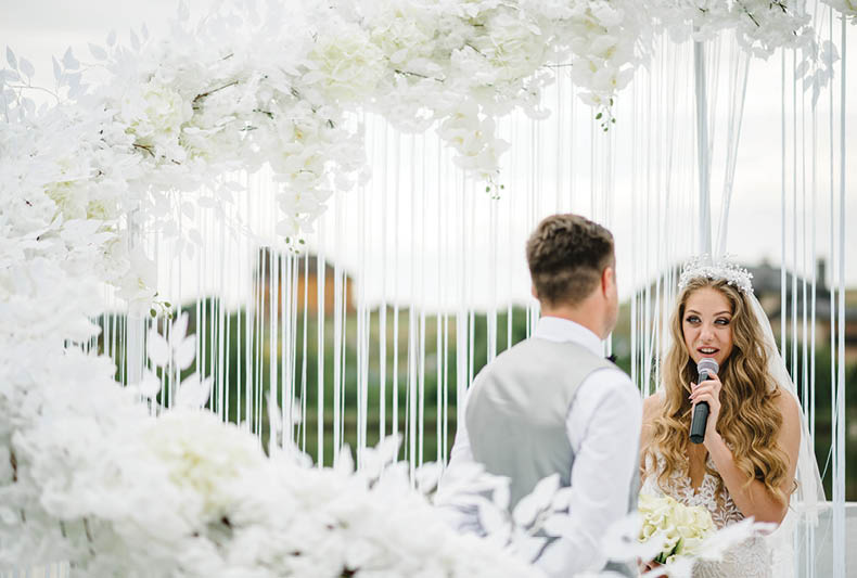 Happy young bride and groom exchanging wedding vows on ceremony  The bride says the promise in the microphone  Fidelity in love 