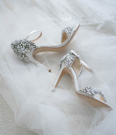 White shoes of the bride in brilliant crystals lie on the veil  Things for an elegant wedding 
