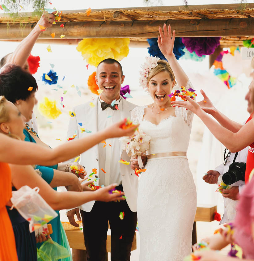 beautiful  gorgeous blonde bride  and stylish groom under confetti, hawai  colorful sand ceremony  on cyprus