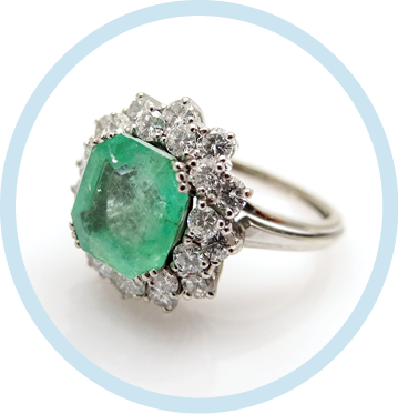 Silver women s vintage design ring in the shape of a flower with large green gem and small diamonds arranged in a circle side view on a white background                        
