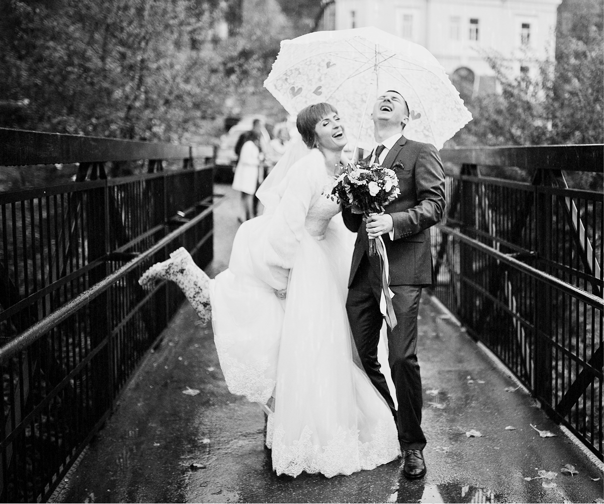 Wedding couple taking a walk with an umbrella on a rainy day  Black and white photo 