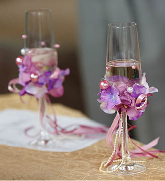 Wedding champagne  flutes decorated with pearls and violet flowers