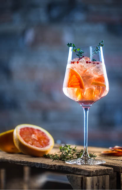 Cocktail drink on a old  wooden board  Alcoholic beverage with tropical fruits red pepper herb and ice 