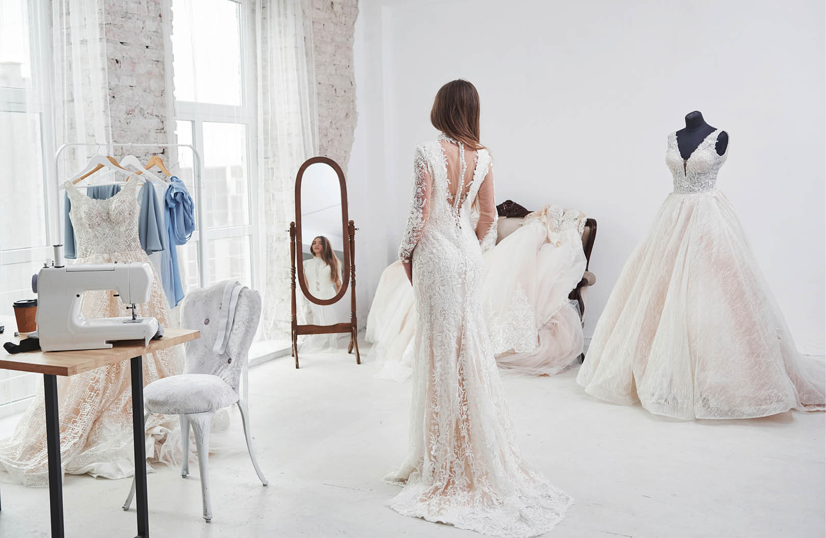 Showing back and looking in the mirror. The process of fitting the dress in the studio of hand crafted clothes.