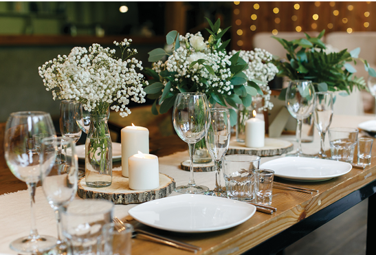 Wedding in rustic style. Wooden tables, gypsophila and greenery, candles.