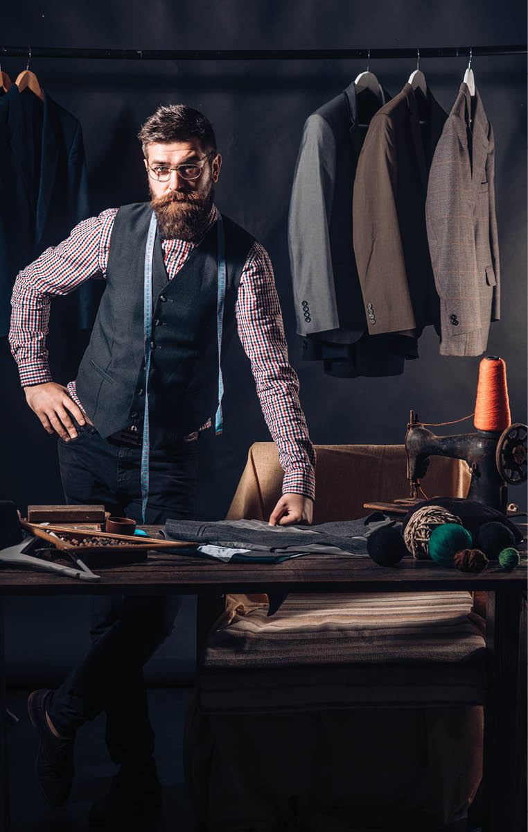 Tailor at work. retro and modern tailoring workshop. sewing mechanization. business dress code. Handmade. Bearded man tailor sewing jacket. suit store and fashion showroom. Talented tailor.