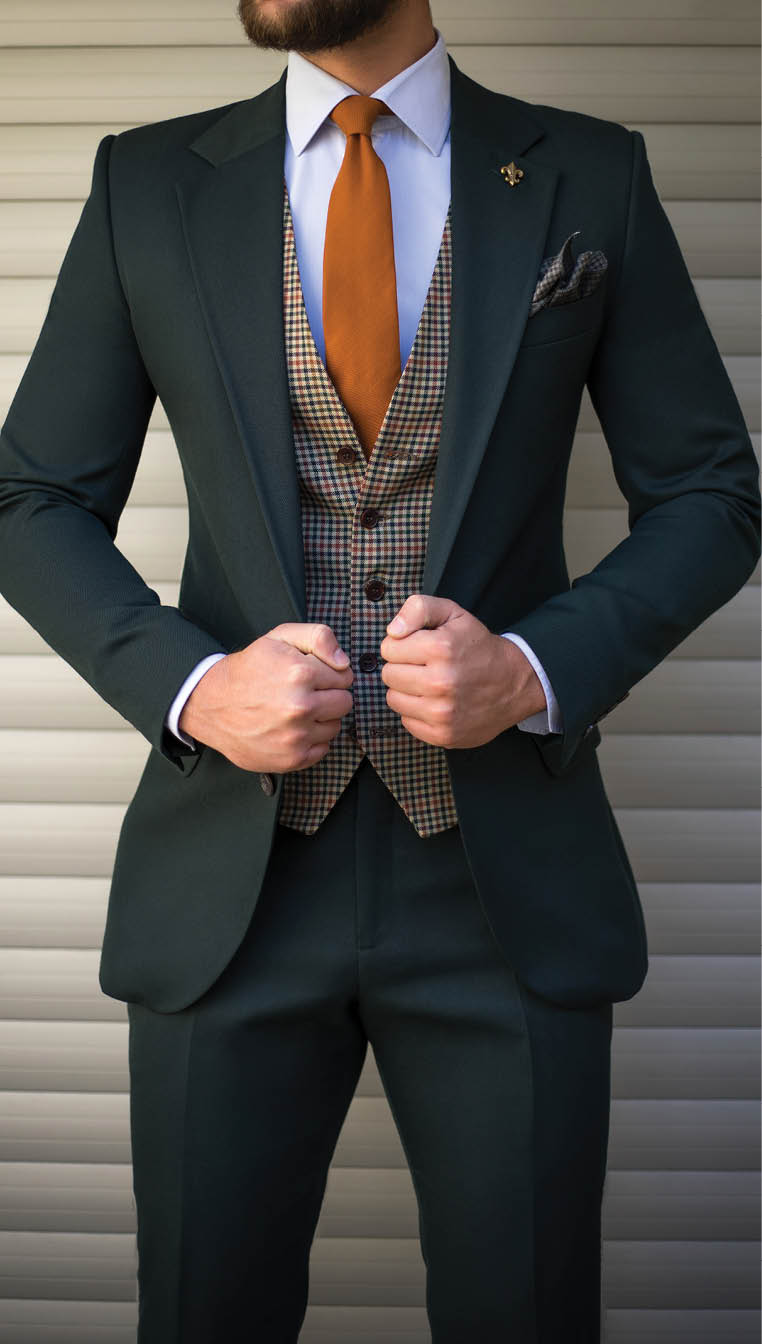 Attractive man in tailored suit posing in front of background