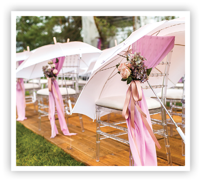 Chairs, flowers and umbrellas at an outdoor ceremony 