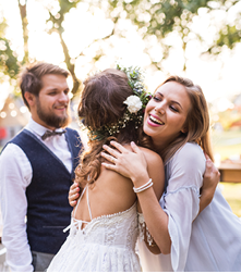 Young girl congratulating bride and groom at wedding reception in the backyard 