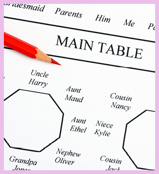 Close up of a wedding seating plan diagram showing the main tables for bride and groom and family members with a red pencil handy for making those inevitable changes