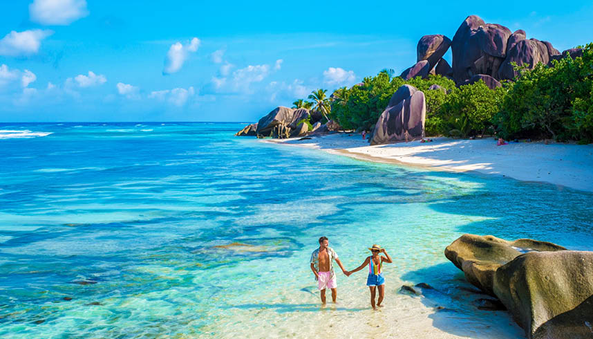 Anse Source d'Argent, La Digue Seychelles, a young couple of men and women on a tropical beach during a luxury vacation in Seychelles. Tropical beach Anse Source d'Argent, La Digue Seychelles
