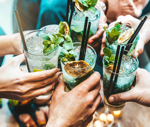 Happy friends group cheering mojito drinks at fancy bar restaurant - Young people having fun toasting cocktail glasses enjoying happy hour at rooftop pub - Party time, life style and youth concept