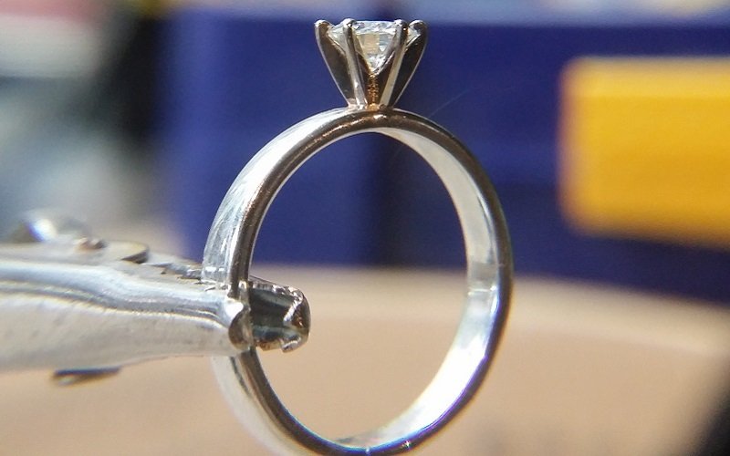 Man studies jewellery design to propose with a handmade engagement ring