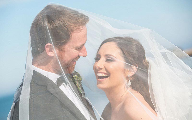 bride and groom under veil