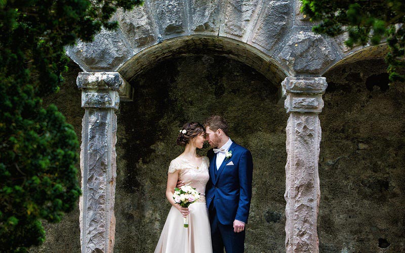 bride and groom under arcg