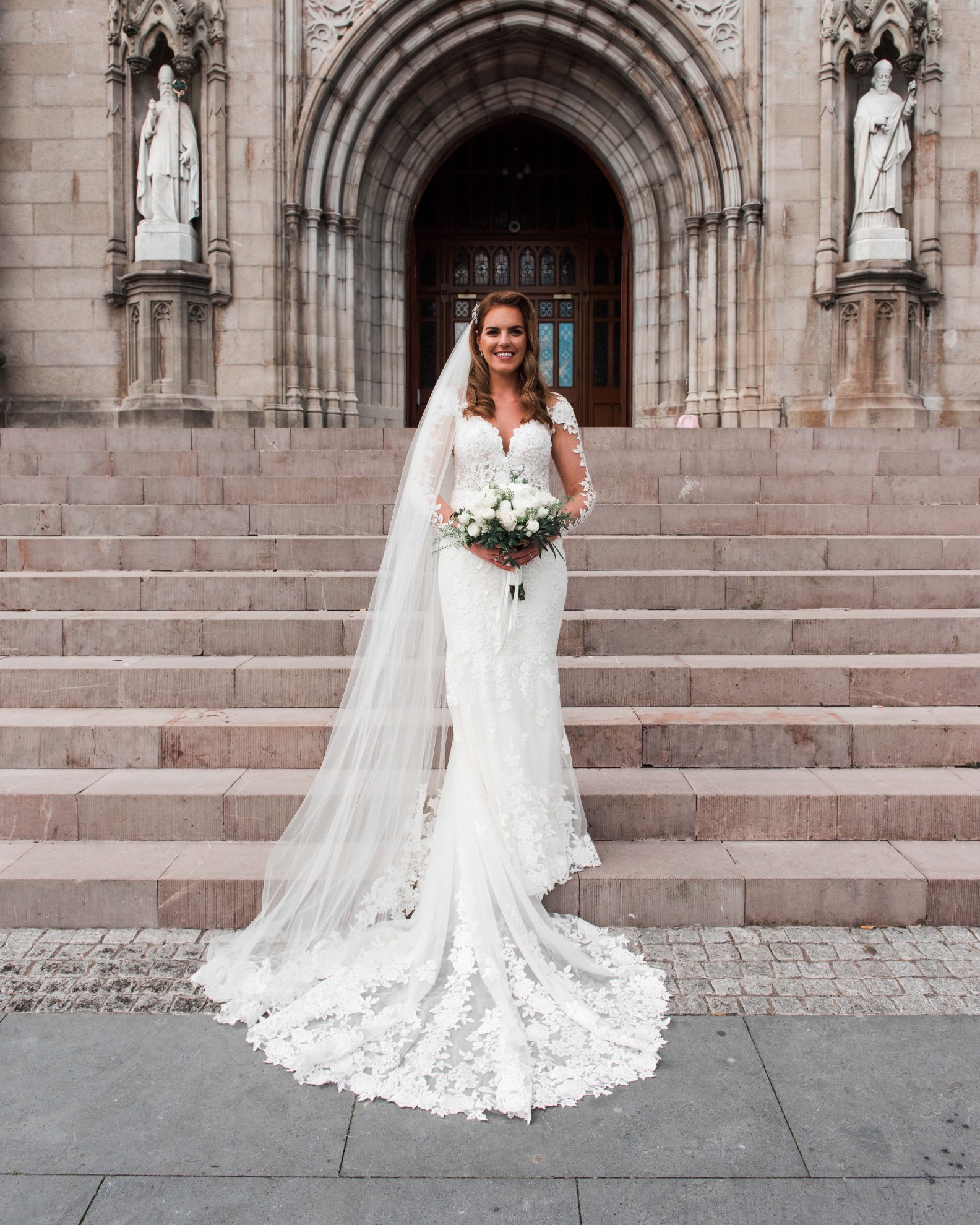 Seidy in her wedding dress on the step so fthe cathedral