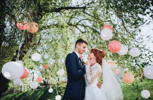 Bride and groom in summer garden with chinese lanterns
